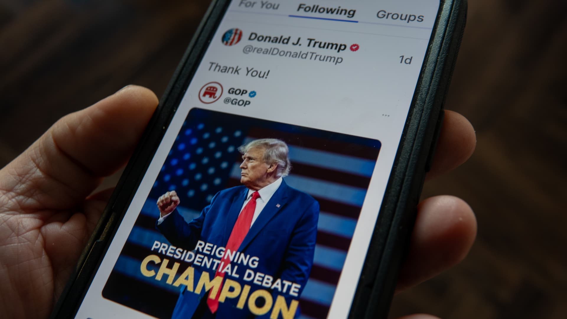 Close-up of a smartphone showing live crypto prediction odds for 2024 US presidential election candidates on a blockchain market app