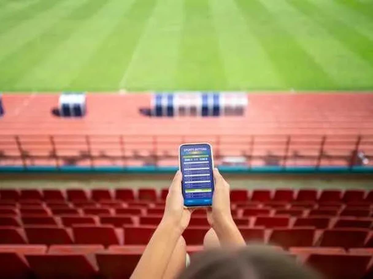 Dynamic blockchain network overlay superimposed on a vibrant live sports stadium, illustrating instant settlements in sports prediction markets